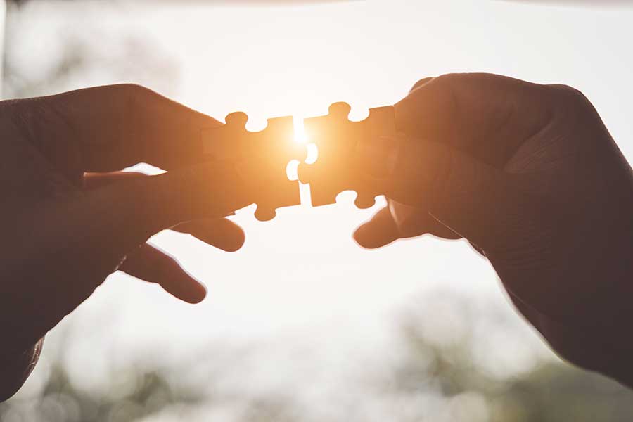2 Hände halten jeweils ein Puzzlestück